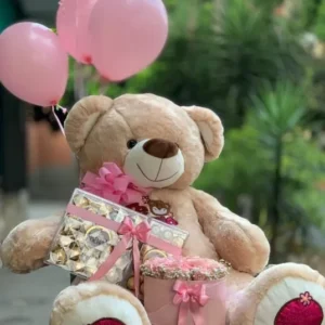 Oso gigante con chocolates Ferrero Rocher, cilindro en rosas y globos con helio